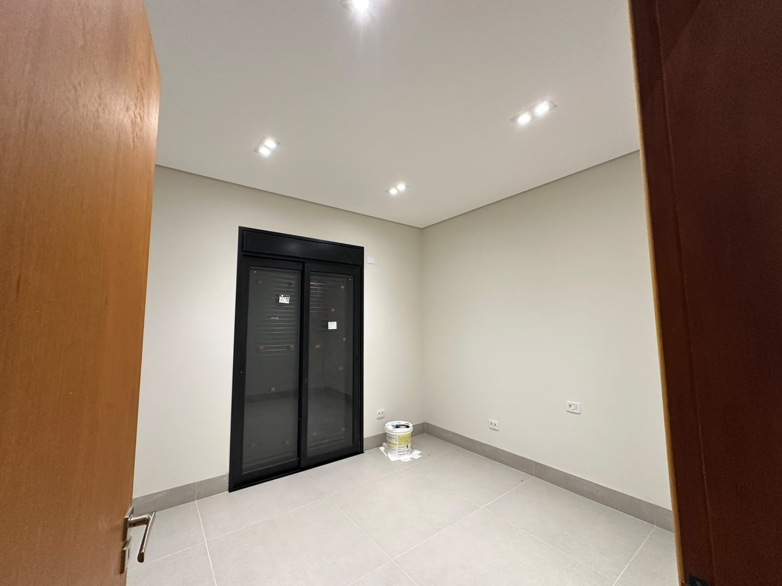 Quarto com porta de correr preta e spots embutidos